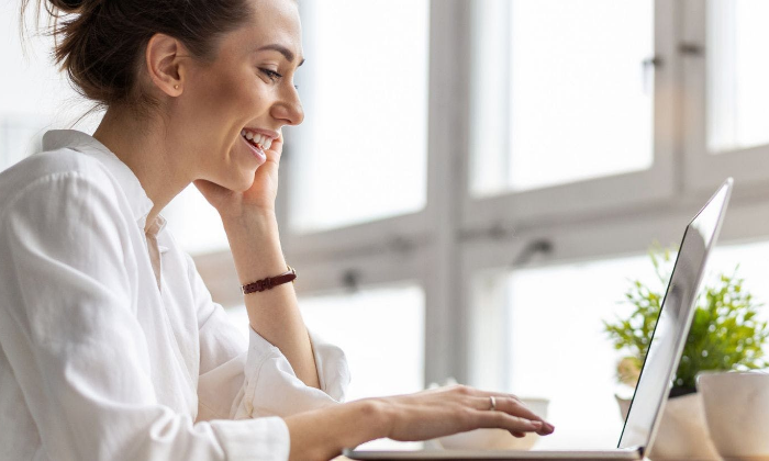 Woman smiling whiel sitting at computer